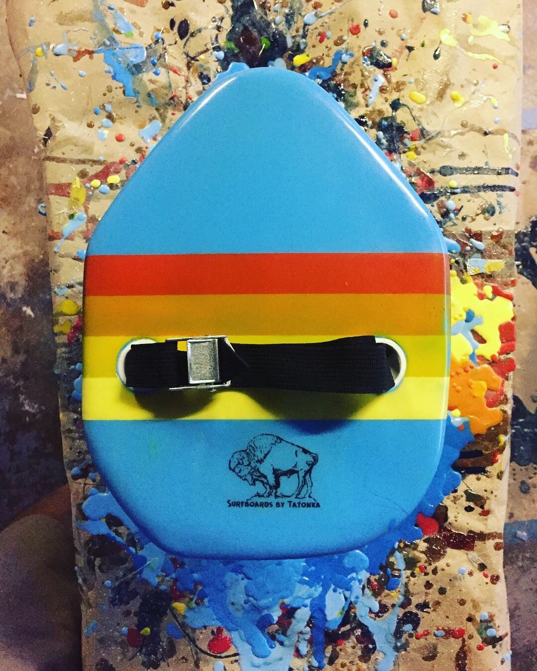 Blue handplane with orange and yellow bands on a paint-covered workbench